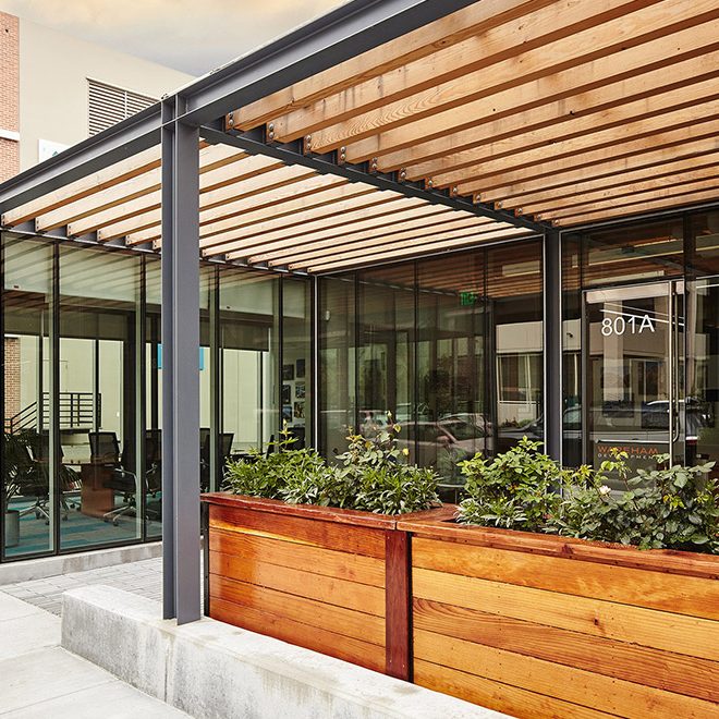 glass entry with wooden accents and planters | Rossi Builders Photos